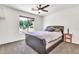 Modern bedroom with a neutral carpet, black upholstered bed frame, and bright sun-filled window view at 2699 E Claxton Rd, Gilbert, AZ 85297