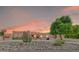 Stunning home with desert landscaping, a large tree, and a serene ambiance at sunset at 2699 E Claxton Rd, Gilbert, AZ 85297