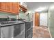 Well-lit laundry room with modern washer and dryer, tiled floor, ample storage, and utility sink at 2699 E Claxton Rd, Gilbert, AZ 85297