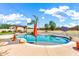 Backyard with a sparkling custom pool, rock accents, mature palm trees, and a grassy play area at 2699 E Claxton Rd, Gilbert, AZ 85297