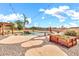 Lush backyard featuring a custom pool, rock waterfall, stone paths, mature landscaping, and a shaded pergola at 2699 E Claxton Rd, Gilbert, AZ 85297