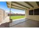 Relaxing covered patio showcasing low-maintenance backyard with artificial turf and rock landscaping at 3011 W Salter Dr, Phoenix, AZ 85027