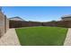 Spacious backyard featuring lush artificial grass, rock border, and block wall for added privacy at 3011 W Salter Dr, Phoenix, AZ 85027