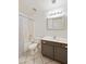 Bright bathroom features a shower-tub combo with gray vanity and a decorative framed mirror at 3011 W Salter Dr, Phoenix, AZ 85027