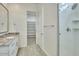 Bathroom featuring granite vanity, glass shower, and walk-in closet at 31570 N 123Rd Ln, Peoria, AZ 85383