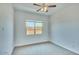 Bedroom featuring carpet, ceiling fan and window with neighborhood views at 31570 N 123Rd Ln, Peoria, AZ 85383