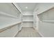 Walk-in closet featuring carpeted floors and shelving for ample storage at 31570 N 123Rd Ln, Peoria, AZ 85383