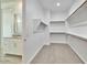 Walk-in closet with rods and shelving, located off a bathroom with a granite vanity at 31570 N 123Rd Ln, Peoria, AZ 85383