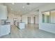 Open concept kitchen with white cabinets, stainless appliances, and tile floors that flow into the living area at 31570 N 123Rd Ln, Peoria, AZ 85383