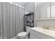 Cozy bathroom featuring a shower with a black and white patterned curtain, a shelf, and a white sink at 3207 W Michigan Ave, Phoenix, AZ 85053