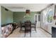Inviting dining area with green accent wall, modern light, and white tile floors at 3207 W Michigan Ave, Phoenix, AZ 85053