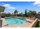 A spacious backyard featuring a sparkling swimming pool surrounded by lush landscaping and a patio area at 3207 W Michigan Ave, Phoenix, AZ 85053