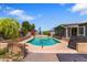Backyard pool area with lush greenery, patio space, and a view of the surrounding landscape at 3207 W Michigan Ave, Phoenix, AZ 85053