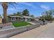 Single story home featuring an updated desert landscape with low walls, artificial grass, and a mature shade tree at 3825 E Captain Dreyfus Ave, Phoenix, AZ 85032