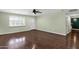 Bright living room featuring hardwood floors, a ceiling fan, fresh paint, and abundant natural light through plantation shutters at 3825 E Captain Dreyfus Ave, Phoenix, AZ 85032