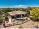 Aerial view of desert landscaping, sparkling pool, extended covered patio, and breathtaking mountain views at 41903 N Golf Crest Rd, Anthem, AZ 85086