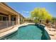 Beautiful backyard with pool, covered patio, and mature desert landscaping, creating a private retreat at 41903 N Golf Crest Rd, Anthem, AZ 85086