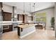 Well-lit kitchen featuring a large island, stainless steel appliances, and dark wood cabinets at 41903 N Golf Crest Rd, Anthem, AZ 85086