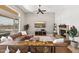 Open living room featuring a stone fireplace, large windows, and a cozy sectional sofa with decor at 41903 N Golf Crest Rd, Anthem, AZ 85086