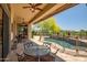 Covered patio featuring an outdoor seating area and a view of the pool at 41903 N Golf Crest Rd, Anthem, AZ 85086