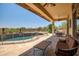 Covered patio featuring a pool with a safety fence and an outdoor seating area at 41903 N Golf Crest Rd, Anthem, AZ 85086