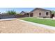 Landscaped backyard with artificial turf, gravel beds, and paved pathways for easy maintenance at 41903 W Rojo St, Maricopa, AZ 85138