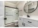 Modern bathroom with a black framed glass shower and a white vanity at 41903 W Rojo St, Maricopa, AZ 85138