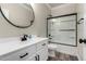 Bathroom featuring black framed glass shower and white vanity with black hardware at 41903 W Rojo St, Maricopa, AZ 85138