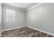 Bright bedroom showcasing wood-look floors and a window with blinds at 41903 W Rojo St, Maricopa, AZ 85138