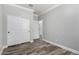 Bedroom featuring wood-look floors, white trim, and a closet with sliding doors at 41903 W Rojo St, Maricopa, AZ 85138