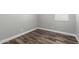 Neutral bedroom featuring wood-look floors, white trim, and a window at 41903 W Rojo St, Maricopa, AZ 85138