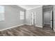 Light-filled bedroom with wood-look floors, white trim, and a window with blinds at 41903 W Rojo St, Maricopa, AZ 85138