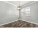 Bright dining room with wood floors and a modern chandelier at 41903 W Rojo St, Maricopa, AZ 85138