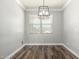 Bright dining room with wood floors and a modern chandelier at 41903 W Rojo St, Maricopa, AZ 85138