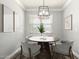 Bright dining room with a round table, wood floors, and a modern chandelier at 41903 W Rojo St, Maricopa, AZ 85138
