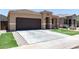 Charming single-story home featuring a desert landscape, brown garage door, and tiled roof at 41903 W Rojo St, Maricopa, AZ 85138