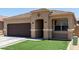 Charming single-story home featuring a desert landscape, brown garage door, and tiled roof at 41903 W Rojo St, Maricopa, AZ 85138