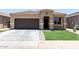 Charming single-story home featuring a desert landscape, brown garage door, and tiled roof at 41903 W Rojo St, Maricopa, AZ 85138