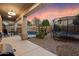Covered patio with outdoor seating and a view of the pool and trampoline, perfect for Gathering fun at 4413 W Phalen Dr, New River, AZ 85087