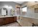 Elegant bathroom featuring a tiled shower with pool views, double sinks, and plenty of vanity space at 4413 W Phalen Dr, New River, AZ 85087