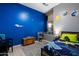 Vibrant bedroom with a unique blue wall design, wood-look floors, and playful decor at 4413 W Phalen Dr, New River, AZ 85087