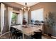 Modern dining room with ample lighting, neutral colors, and large windows offering backyard views at 4413 W Phalen Dr, New River, AZ 85087