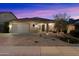 Front exterior of the home at twilight, showing desert landscaping, covered porch and two car garage at 4413 W Phalen Dr, New River, AZ 85087