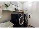 Well-lit laundry room with modern washer and dryer, utility sink, and convenient shelving at 4413 W Phalen Dr, New River, AZ 85087