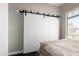 Bedroom features a sliding barn door and a window providing natural light at 4662 S Calico Rd, Gilbert, AZ 85297
