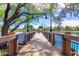 Scenic community dock with wood planks and black metal railings extending over the serene lake with hanging lights at 4662 S Calico Rd, Gilbert, AZ 85297