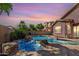 Backyard pool with rock features and desert landscaping offers a luxurious outdoor retreat at sunset at 4662 S Calico Rd, Gilbert, AZ 85297