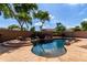 Backyard pool oasis featuring a rock waterfall and lush landscaping at 4662 S Calico Rd, Gilbert, AZ 85297