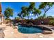 Backyard oasis with a stunning pool, rock features, and ample lounge seating at 4662 S Calico Rd, Gilbert, AZ 85297