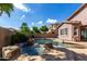 Inviting backyard pool with a rock waterfall and charming stone patio at 4662 S Calico Rd, Gilbert, AZ 85297